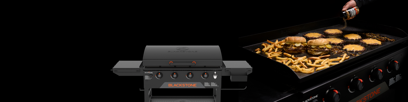 Blackstone griddle with hood featured alongside burgers, cheeseburger patties, and fries cooking on a griddle while a hand sprinkles seasoning over the food.