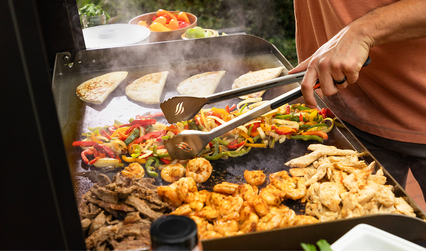 Fajitas, shrimp and vegetables cooking on a Blackstone griddle